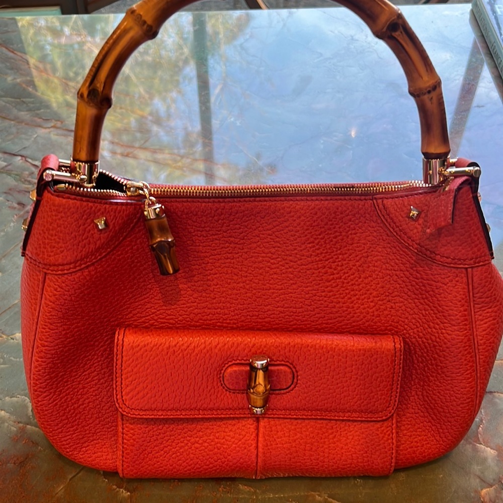 Gucci leather bag with bamboo handle and front pocket.